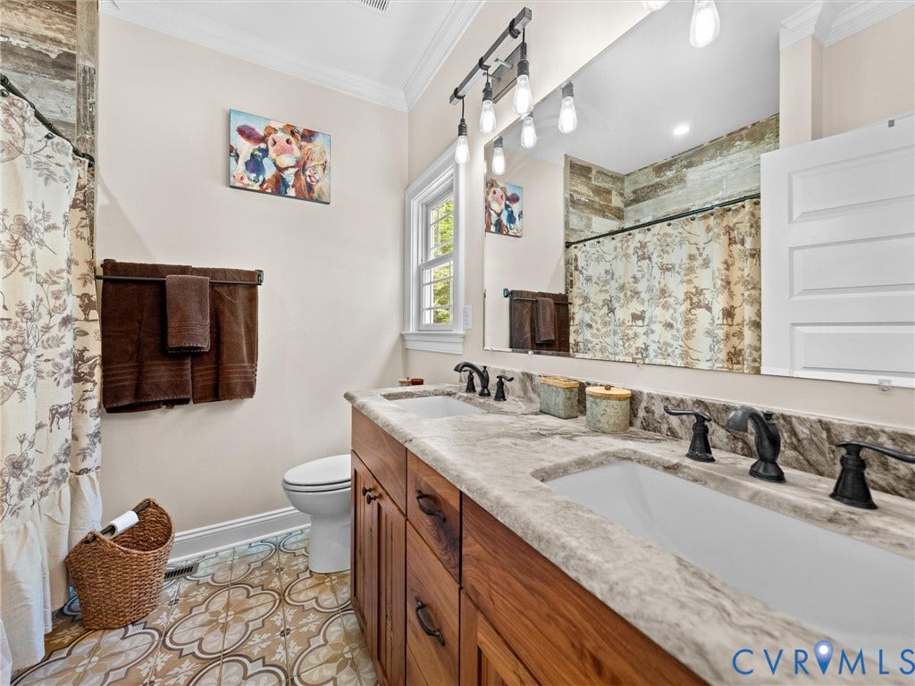 9877 Swinging Bridge Road, Taylors Grove Estates, Quinton, VA 23141 The primary en-suite bath features beautiful tile flooring, leathered granite countertops, a dual-sink vanity, and a tub/shower combination with a tile surround. A thoughtfully designed space combining style and everyday functionality!