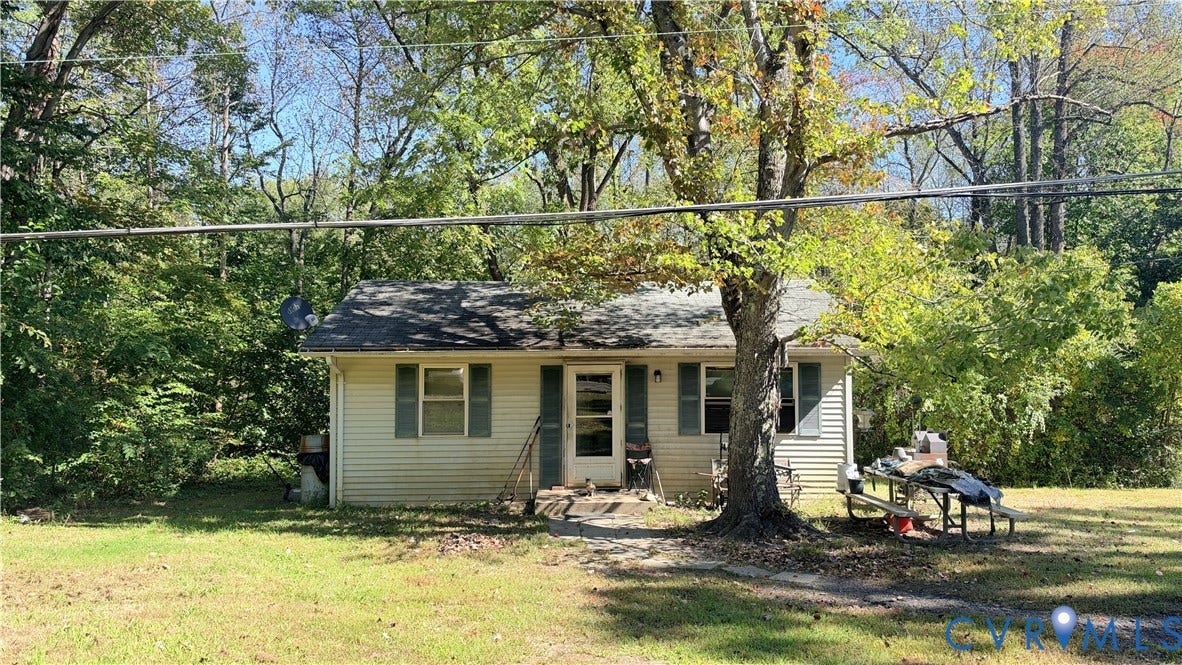 17019 Batestown Road, Batestown, Dumfries, VA 22025 Single-story residence featuring horizontal vinyl siding, a gabled roof, shuttered windows, and mature surrounding trees