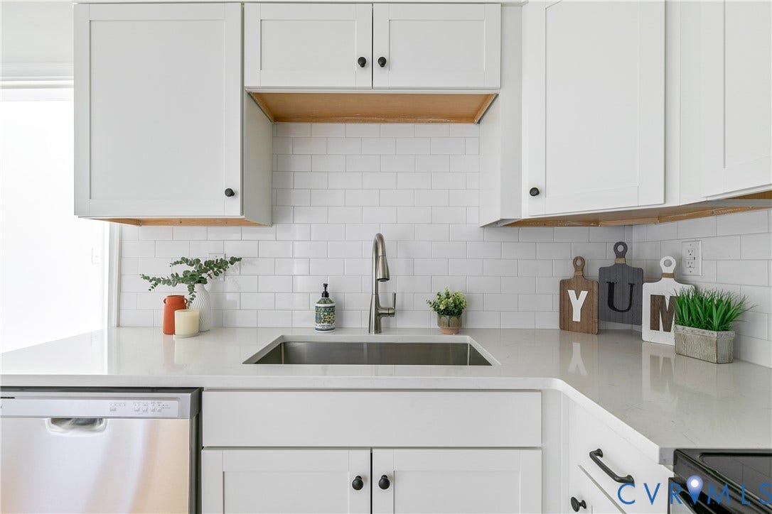 7263 Grace Lane, Mechanicsville, VA 23111 Kitchen featuring white shaker-style cabinetry, a stainless steel sink with a gooseneck faucet, light-toned countertops, white subway tile backsplash, and a built-in stainless steel dishwasher