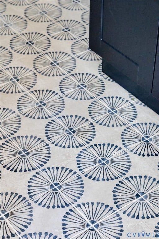 7263 Grace Lane, Mechanicsville, VA 23111 Patterned tile flooring featuring a radial design in a neutral and blue palette, complemented by a dark wood-finish cabinet base