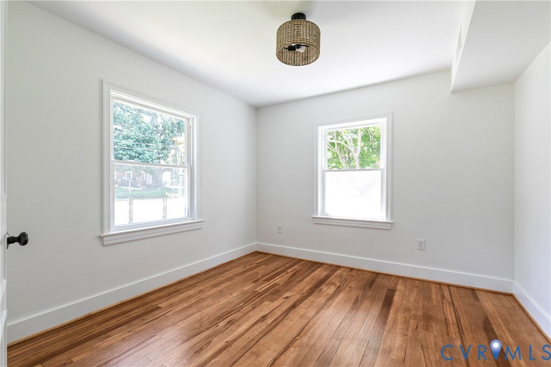 7263 Grace Lane, Mechanicsville, VA 23111 Room featuring wood-finish flooring, two large windows, white walls, and a contemporary ceiling light fixture