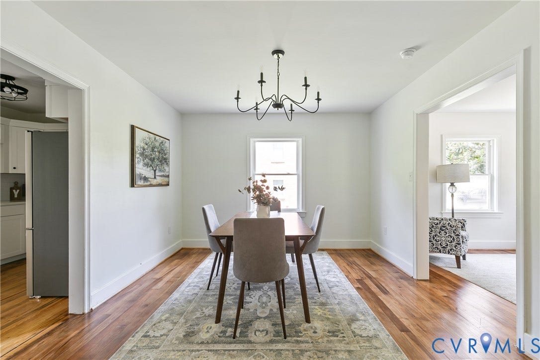 7263 Grace Lane, Mechanicsville, VA 23111 Dining space featuring wood-finish flooring, a black iron chandelier, a window with natural light, and white baseboards