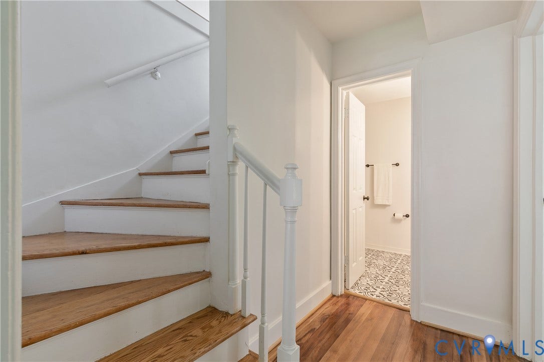 7263 Grace Lane, Mechanicsville, VA 23111 Hardwood flooring extending from the hallway into the visible room, white staircase with wood treads and white risers, white painted balusters, and a white handrail