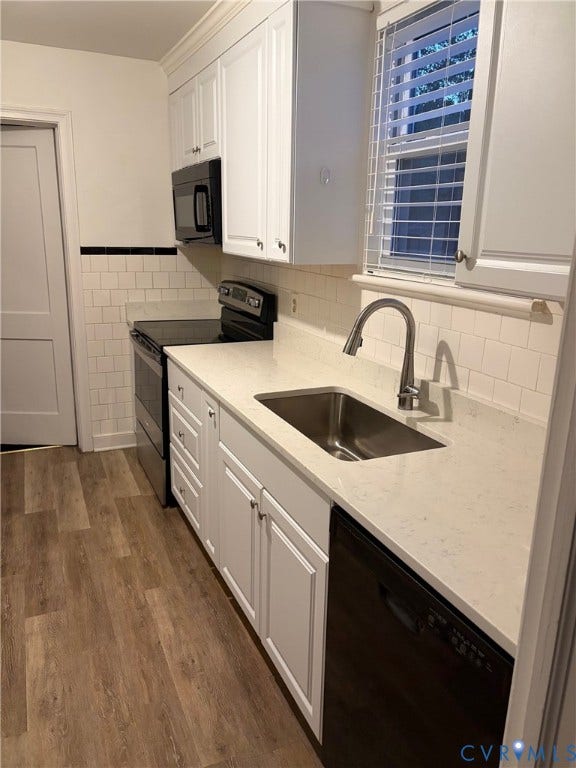 6523 Stuart Avenue, Richmond, VA 23226 Kitchen featuring white cabinetry, quartz countertops, subway tile backsplash with a decorative black accent border, stainless steel undermount sink, and wood-finish flooring