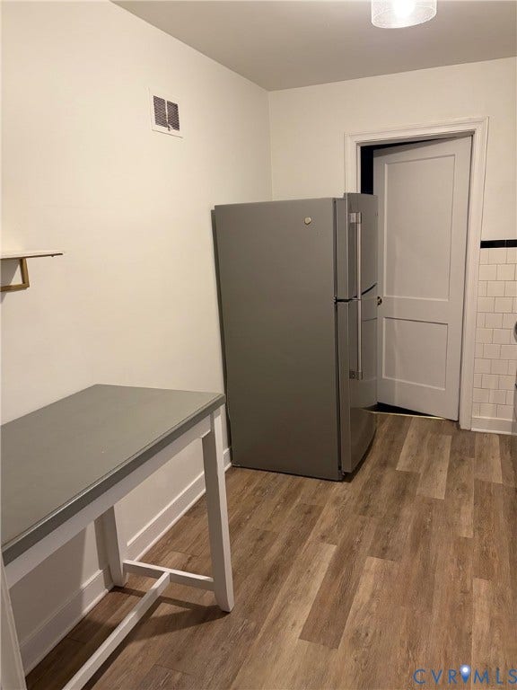 6523 Stuart Avenue, Richmond, VA 23226 Wood-finish flooring, stainless steel refrigerator, white subway tile backsplash with black decorative accent, and recessed ceiling lighting