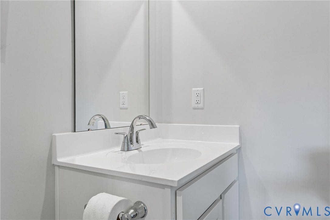 Single-basin vanity with a white countertop, chrome faucet, and integrated mirror