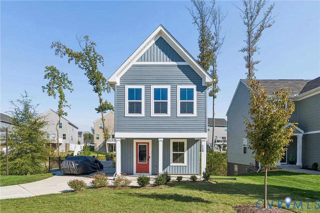 Two-story residence featuring horizontal and vertical lap siding, a covered front porch with square columns, and a front entry door with a glass pane
