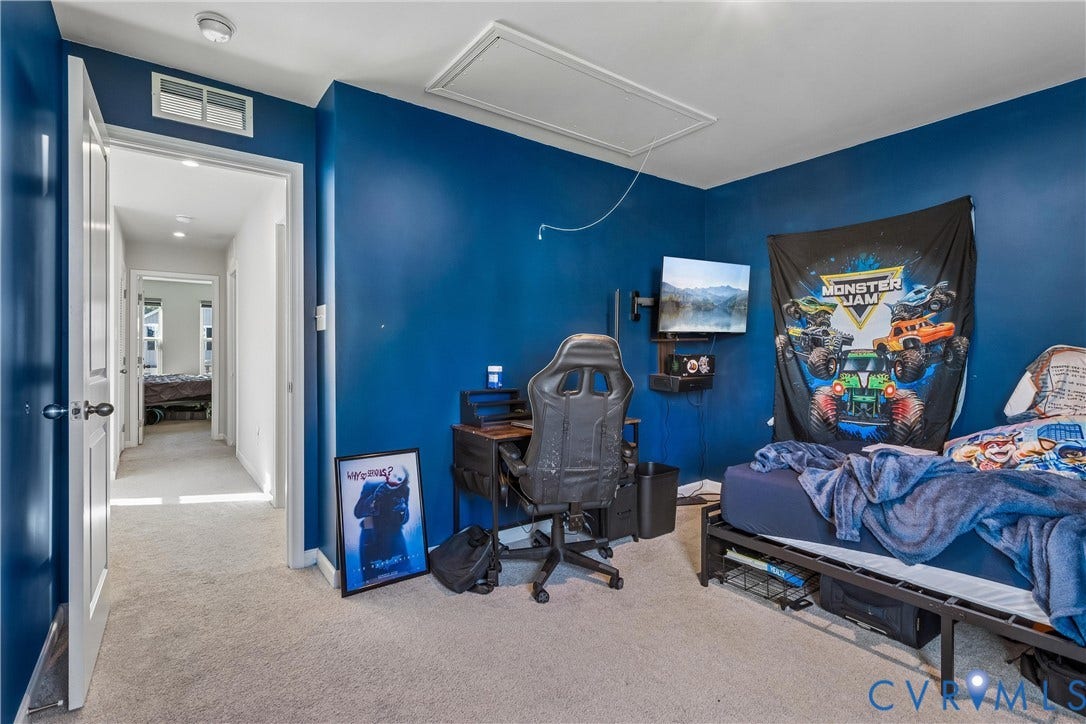 Interior room featuring neutral carpeting, a ceiling-mounted attic access panel, and a dual-panel interior door