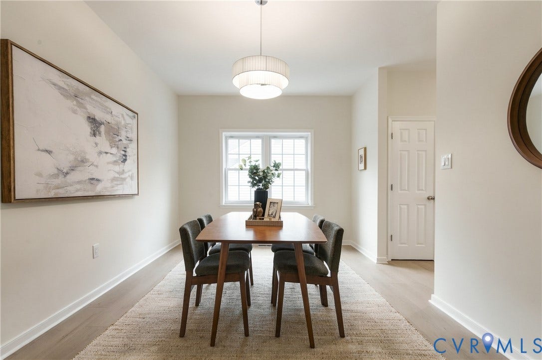 8060 Pebblepath Parkway, Hanover, VA 23111 Neutral interior featuring light-toned wood-finish flooring, multi-tier drum pendant lighting, and a multi-pane grid window
