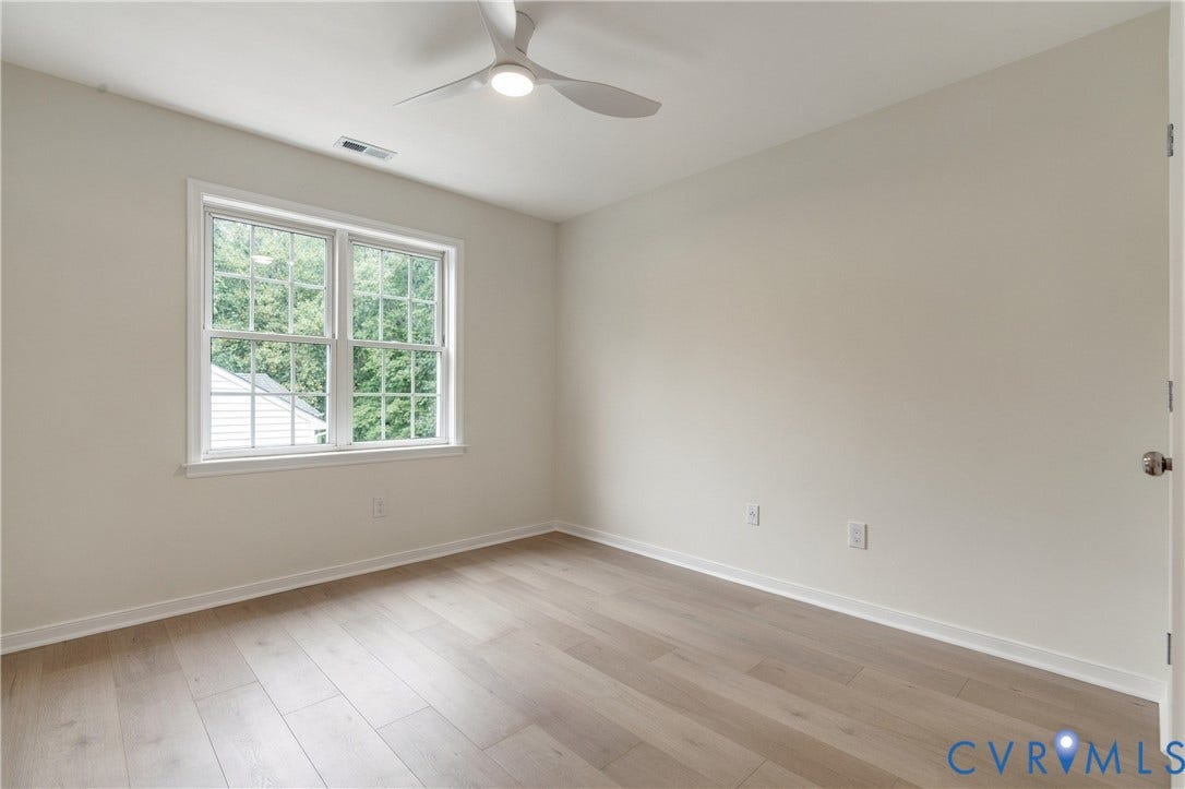 8060 Pebblepath Parkway, Hanover, VA 23111 Neutral-toned room featuring wood-finish flooring, a white three-blade ceiling fan with integrated lighting, and a double-hung window with muntin grids