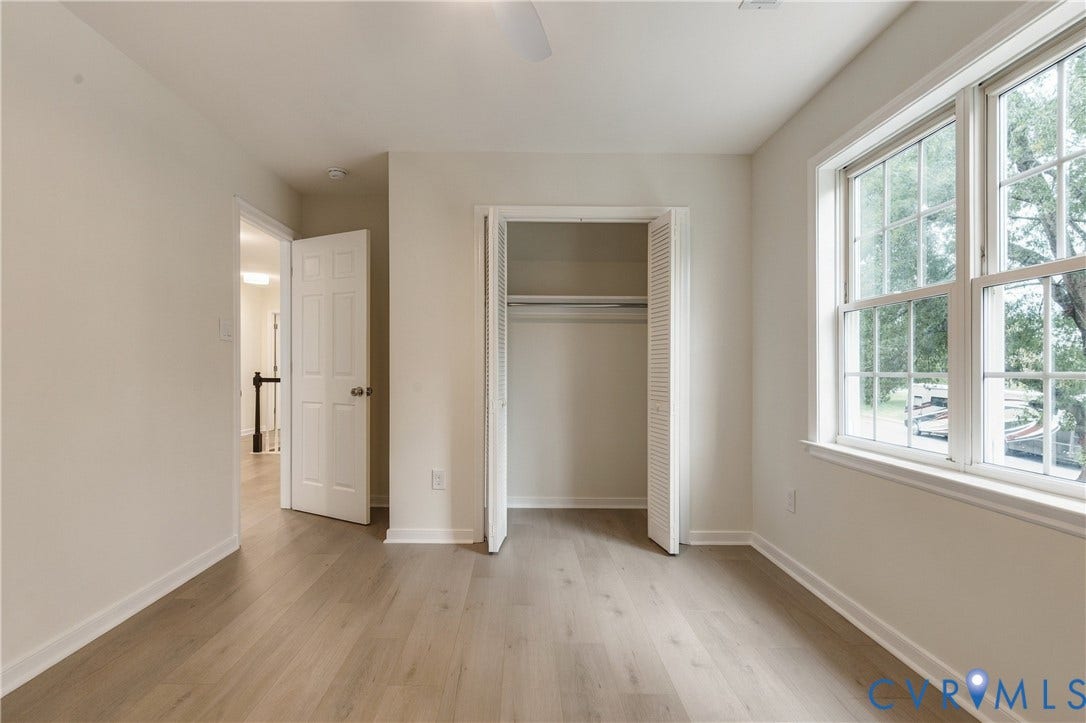 8060 Pebblepath Parkway, Hanover, VA 23111 Neutral-toned interior featuring wood-finish flooring, dual-pane windows, a recessed closet with louvered bi-fold doors, and a six-panel interior door