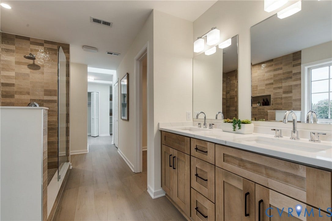 8060 Pebblepath Parkway, Hanover, VA 23111 Bathroom featuring a dual-sink vanity with light wood cabinetry, white countertops, textured horizontal tile shower wall, and wood-finish flooring