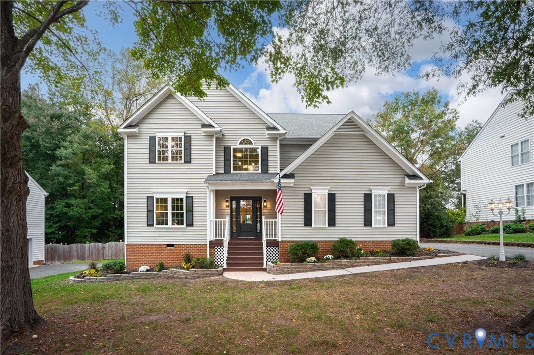 8060 Pebblepath Parkway, Hanover, VA 23111 Two-story exterior featuring light-toned horizontal siding, a partial brick facade, a covered front entry with steps, decorative window shutters, and a stone-lined front landscape border