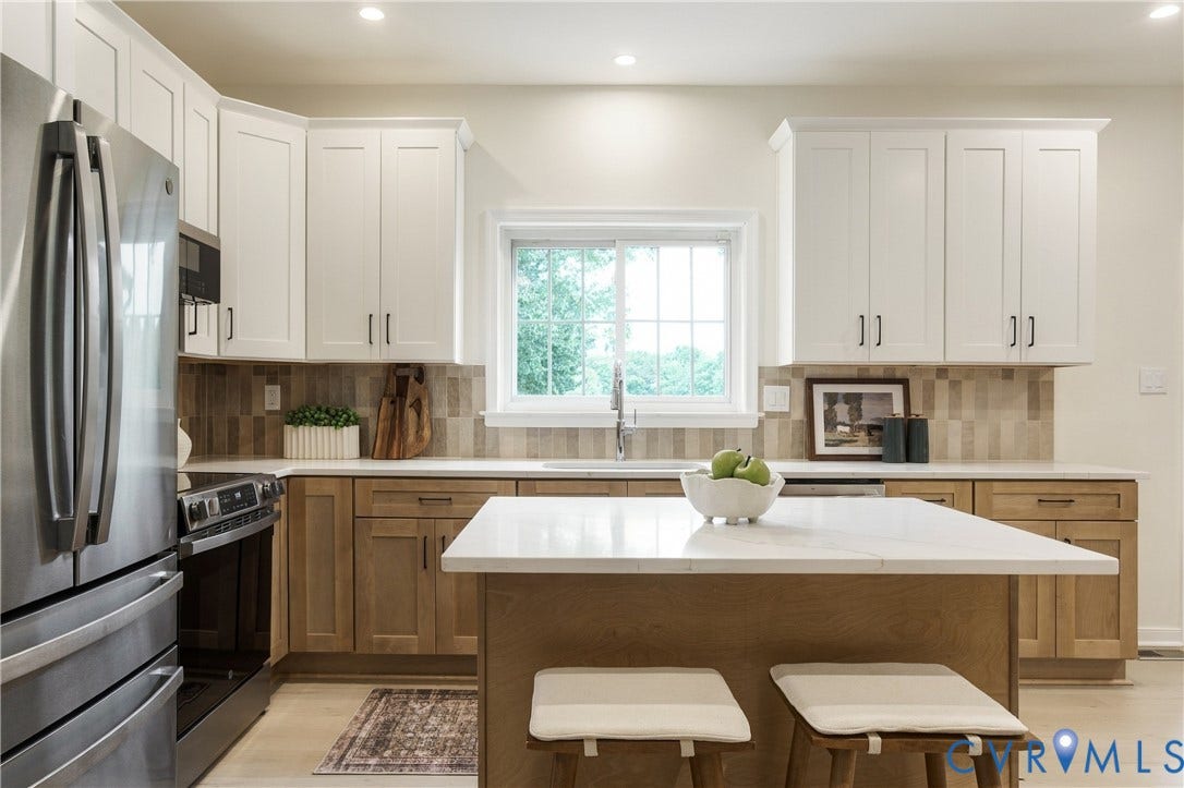 8060 Pebblepath Parkway, Hanover, VA 23111 Kitchen featuring two-tone shaker-style cabinetry, a central island with a solid-surface countertop, stainless steel appliance package, and a tile backsplash