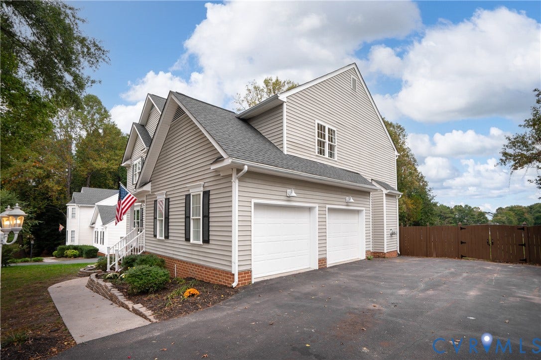 8060 Pebblepath Parkway, Hanover, VA 23111 Two-story exterior featuring horizontal siding, a brick water table, an attached two-car garage, and a paved driveway