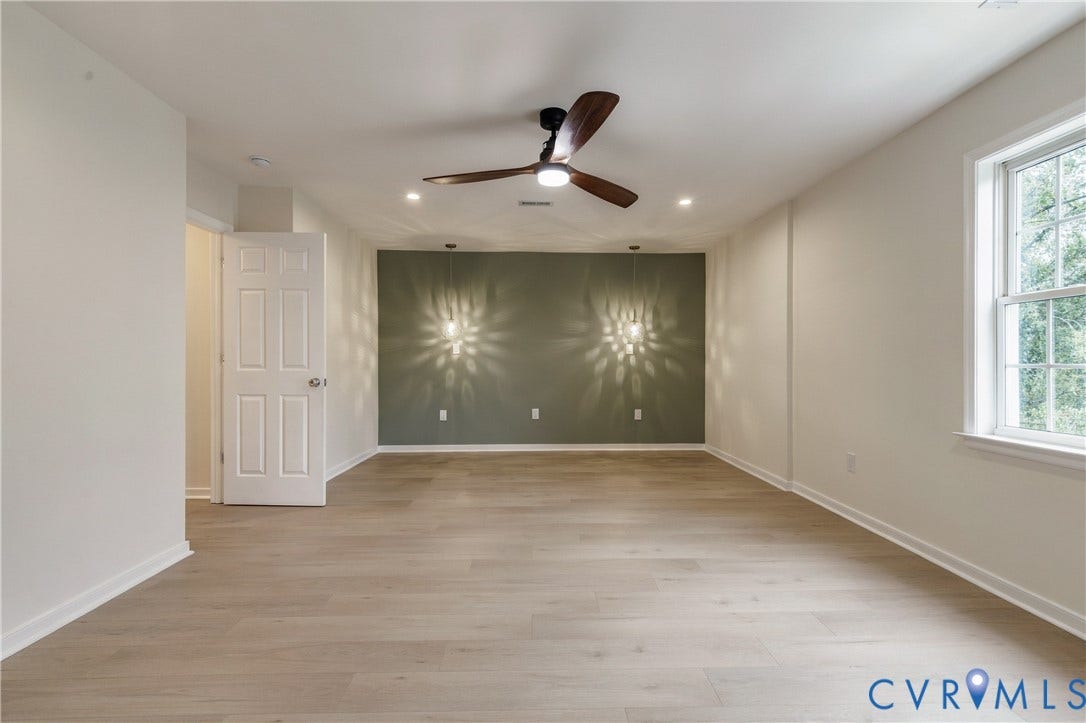 8060 Pebblepath Parkway, Hanover, VA 23111 Interior room featuring wood-finish flooring, a multi-tone accent wall, dual wall-mounted pendant lights, a ceiling fan with integrated lighting, and recessed ceiling lights