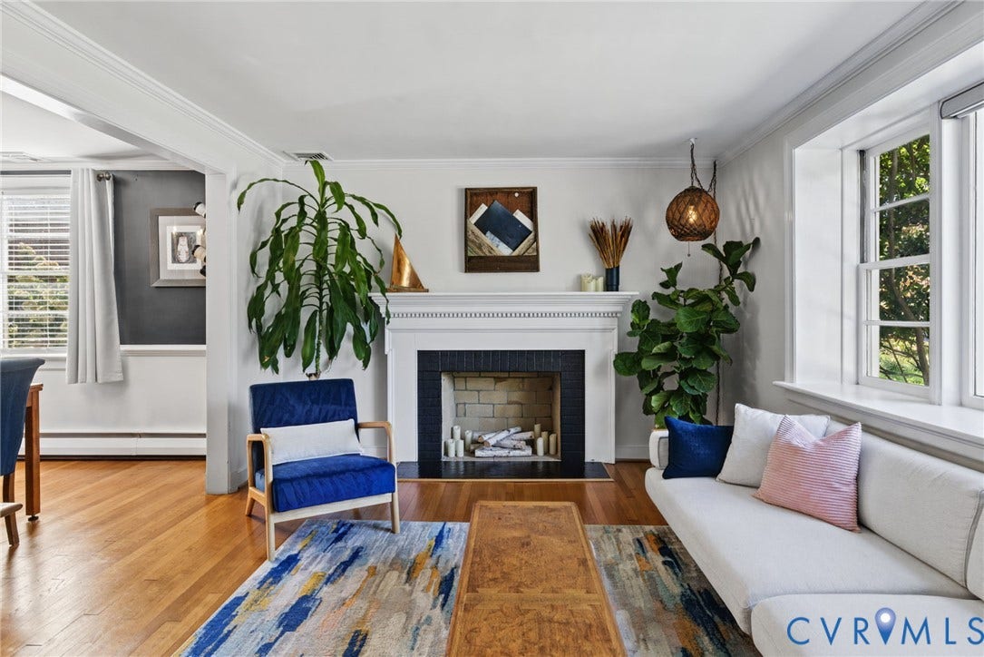 1009 Malvern Avenue, Malvern Gardens, Richmond, VA 23221 Living area featuring wood-finish flooring, a traditional fireplace with a white mantel and black surround, multi-pane windows, and crown molding