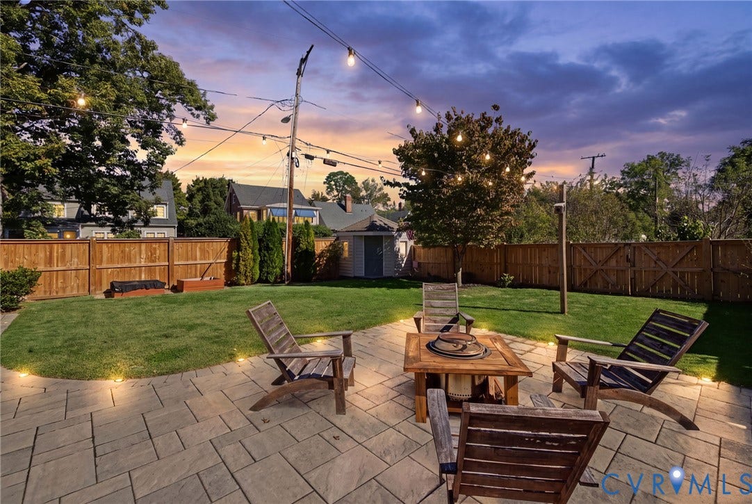 1009 Malvern Avenue, Malvern Gardens, Richmond, VA 23221 Fenced backyard featuring stone paver patio, manicured lawn, perimeter landscape lighting, and overhead string lights