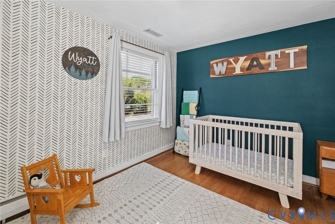 1009 Malvern Avenue, Malvern Gardens, Richmond, VA 23221 Interior room featuring wood-finish flooring, a patterned accent wall, a solid-colored wall, and a window with horizontal blinds