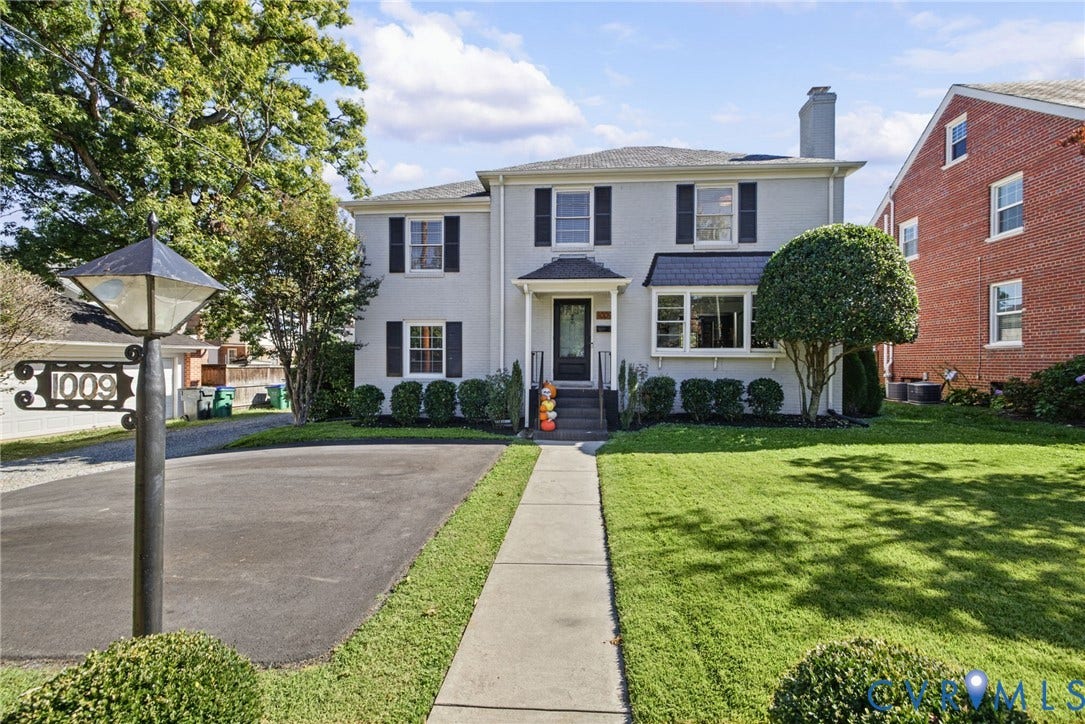 1009 Malvern Avenue, Malvern Gardens, Richmond, VA 23221 Two-story exterior featuring painted masonry siding, dark shutters, an asphalt driveway, a paved walkway, and a chimney stack