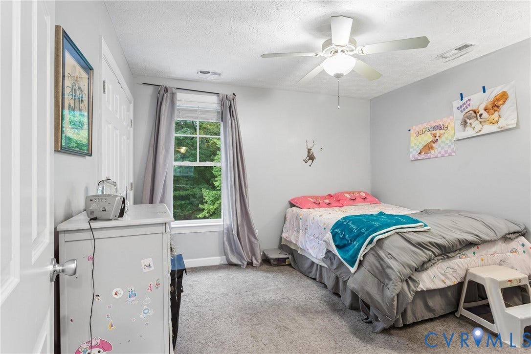 Bedroom featuring neutral wall paint, wall-to-wall carpeting, a multi-pane window, and a ceiling-mounted fan with integrated lighting