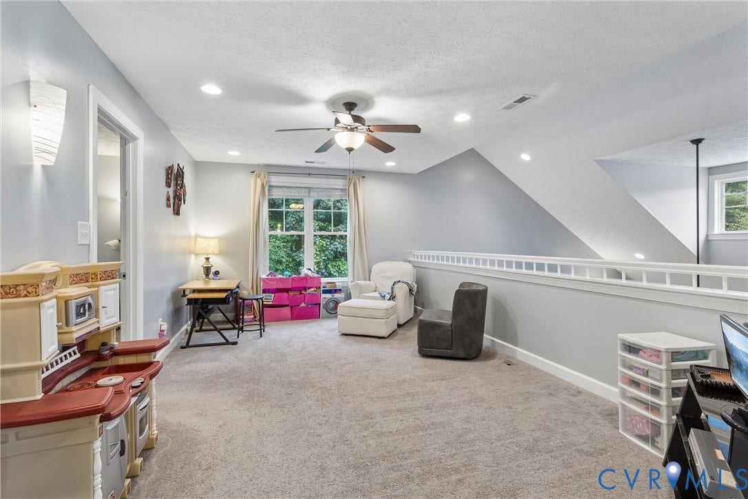 Vaulted ceiling room featuring neutral carpeting, a central ceiling fan with integrated lighting, recessed lighting, and a white balustrade railing