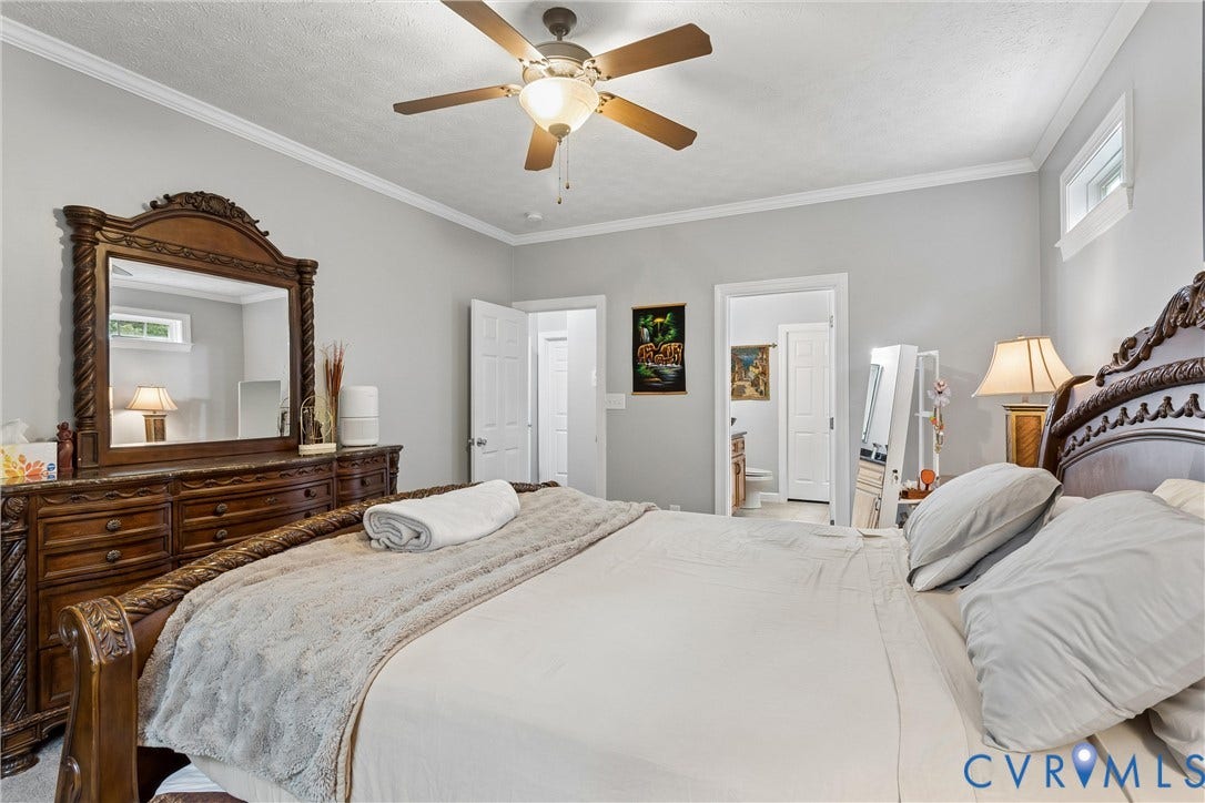 Bedroom featuring crown molding, neutral wall color, and a ceiling fan with integrated lighting