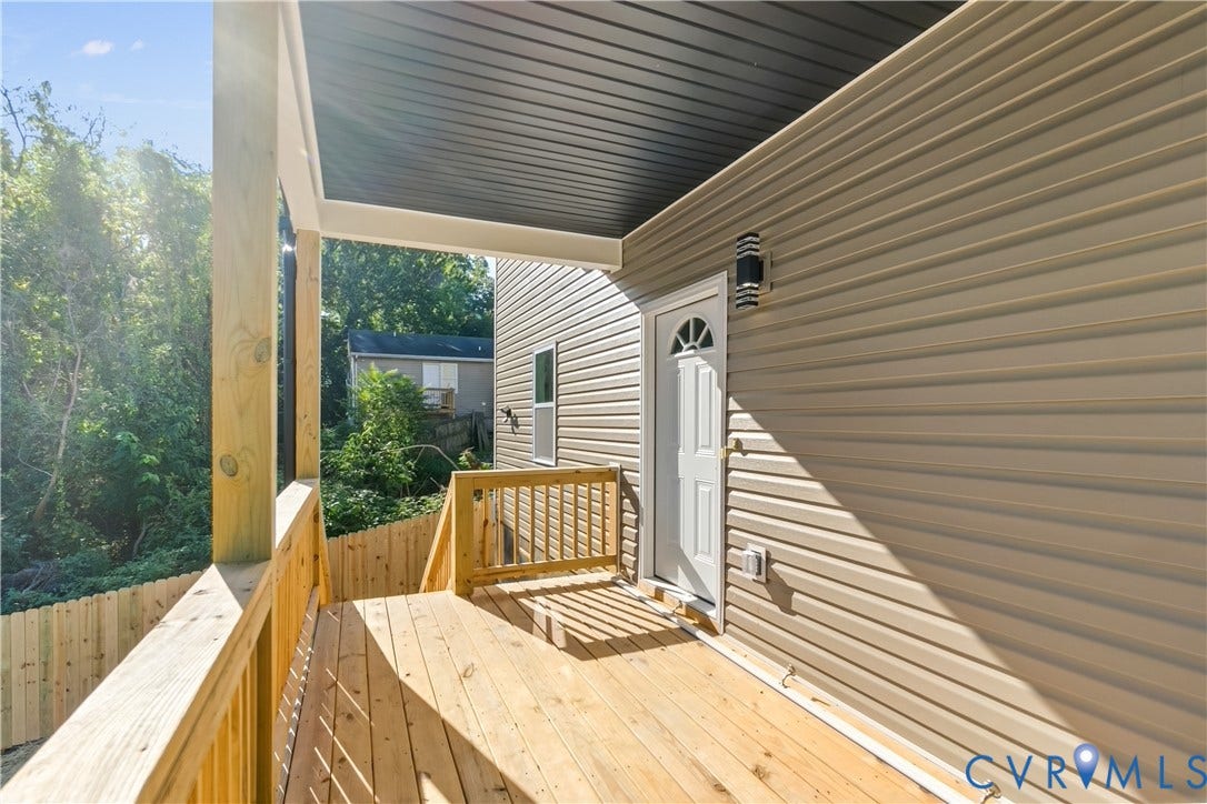 223 S Crater Road, Petersburg, VA 23803 Covered exterior deck with wood-finish decking, natural wood railings, and horizontal light-toned siding