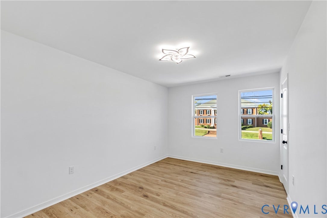 223 S Crater Road, Petersburg, VA 23803 Interior space featuring wood-finish flooring, two double-hung windows, and a decorative flush-mount ceiling fixture