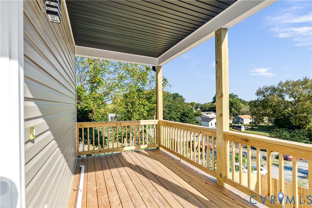 223 S Crater Road, Petersburg, VA 23803 Covered balcony featuring wood-finish decking, light-tone wood railing, and vinyl siding