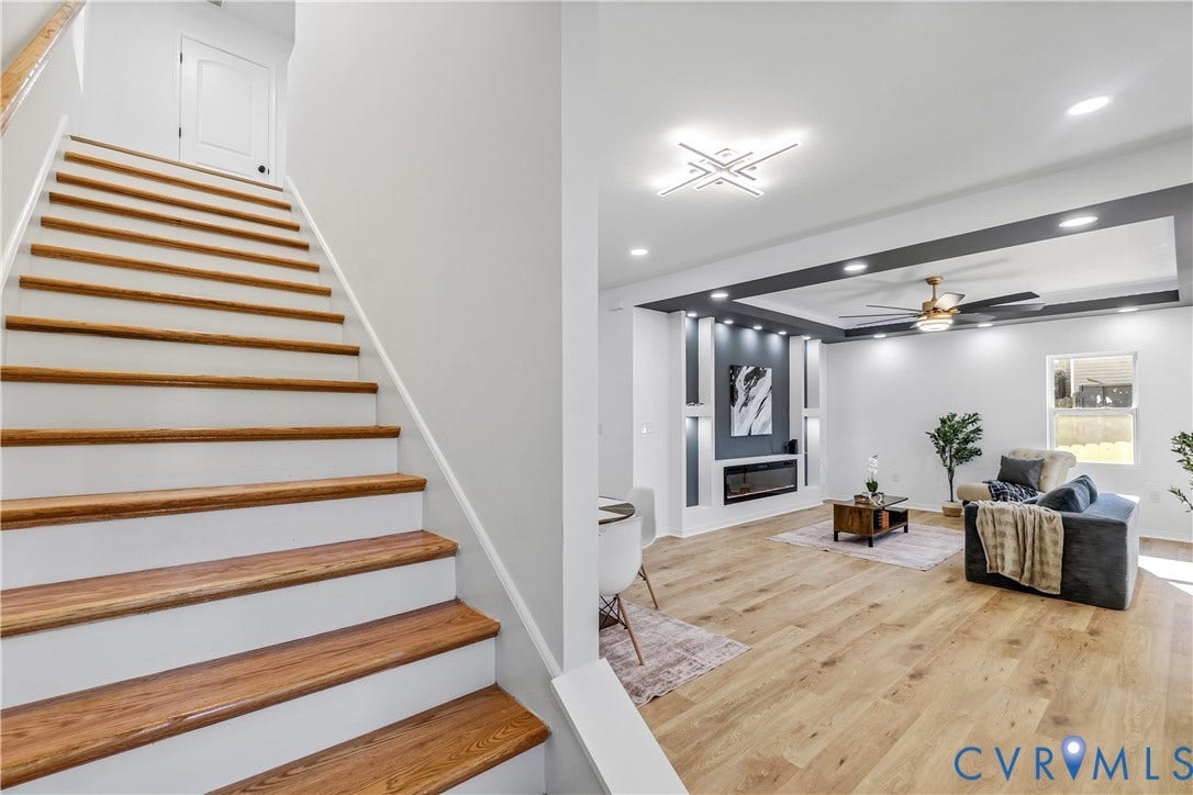 223 S Crater Road, Petersburg, VA 23803 Staircase featuring wood-finish treads and white risers, wood-finish flooring, recessed lighting, built-in electric fireplace with decorative shelving, and a ceiling fan with integrated lighting