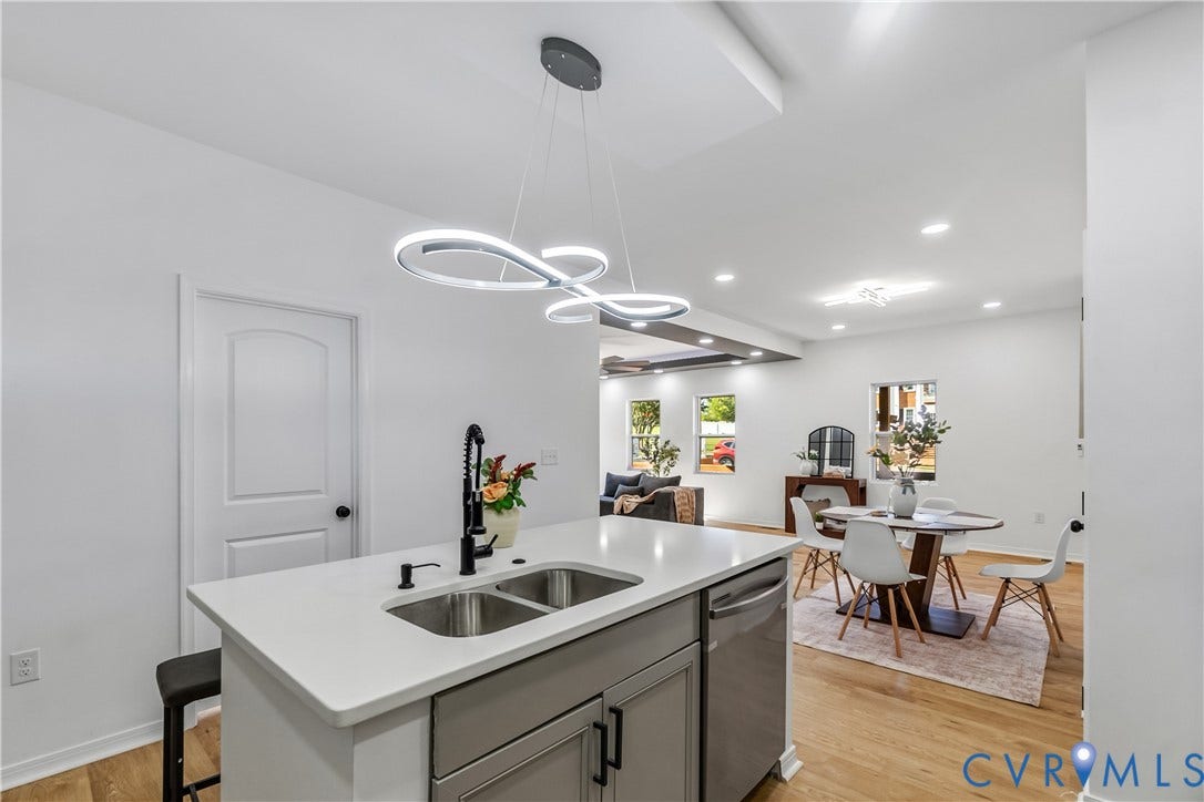 223 S Crater Road, Petersburg, VA 23803 Kitchen island featuring a quartz countertop, dual-basin stainless steel sink, matte black gooseneck faucet, grey cabinetry, and geometric LED pendant lighting