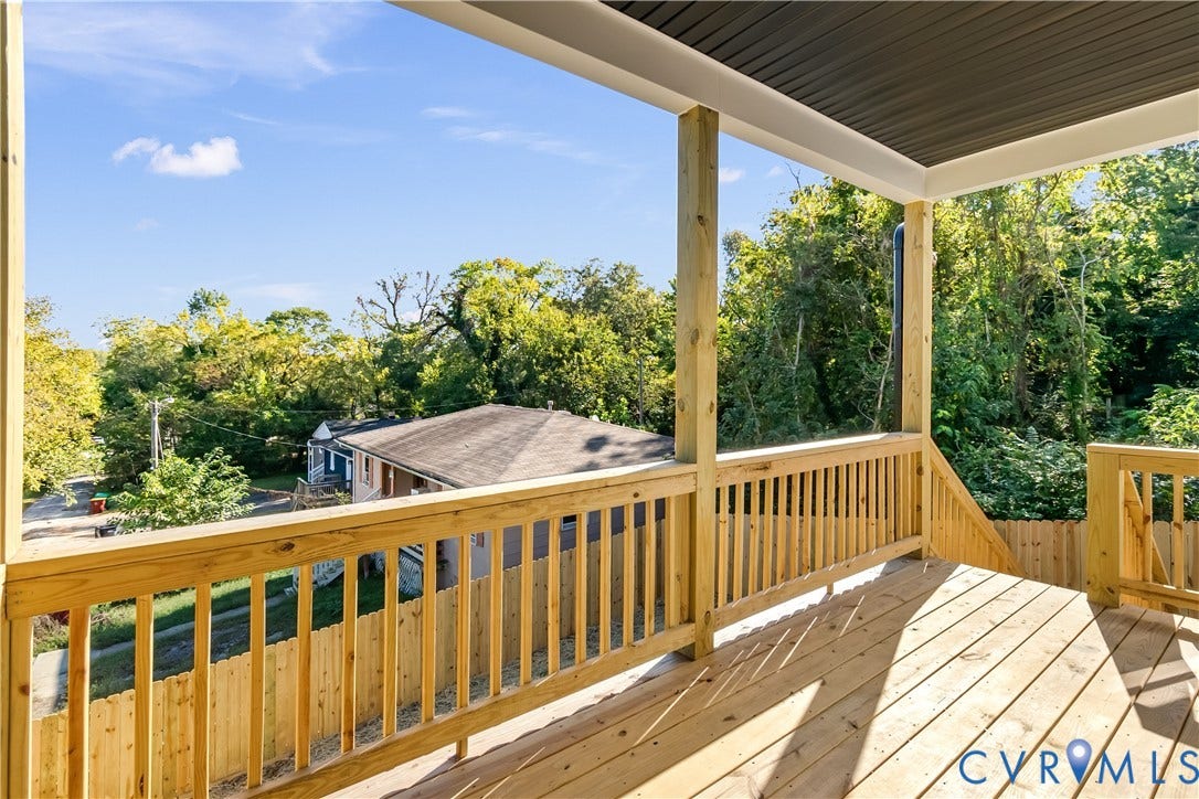 223 S Crater Road, Petersburg, VA 23803 Elevated wood deck featuring vertical wood balusters, a covered ceiling, and natural wood flooring