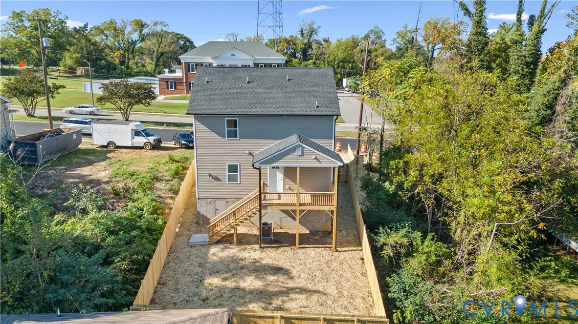 223 S Crater Road, Petersburg, VA 23803 Two-story residence featuring light-toned horizontal siding, a gabled roof, an elevated rear porch with wooden railings, and a fenced backyard