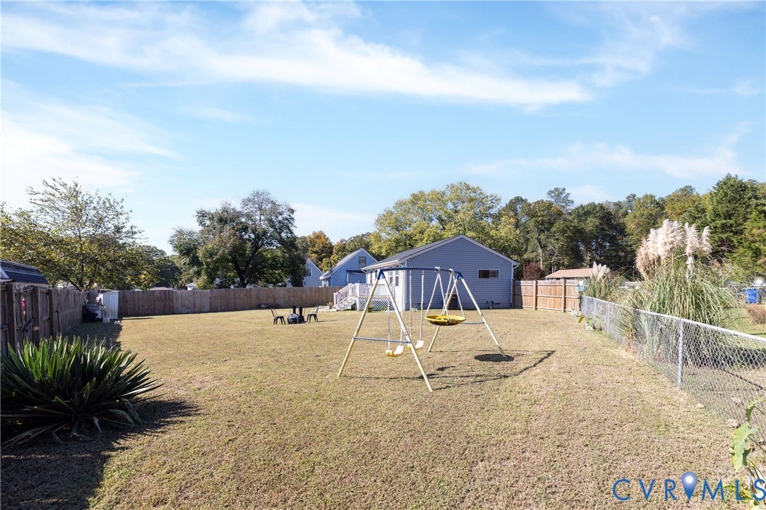 3705 Yard Arm Drive, Chesterfield, VA 23831 Expansive backyard featuring a large grass lawn, perimeter wood fencing, and metal chain-link sections