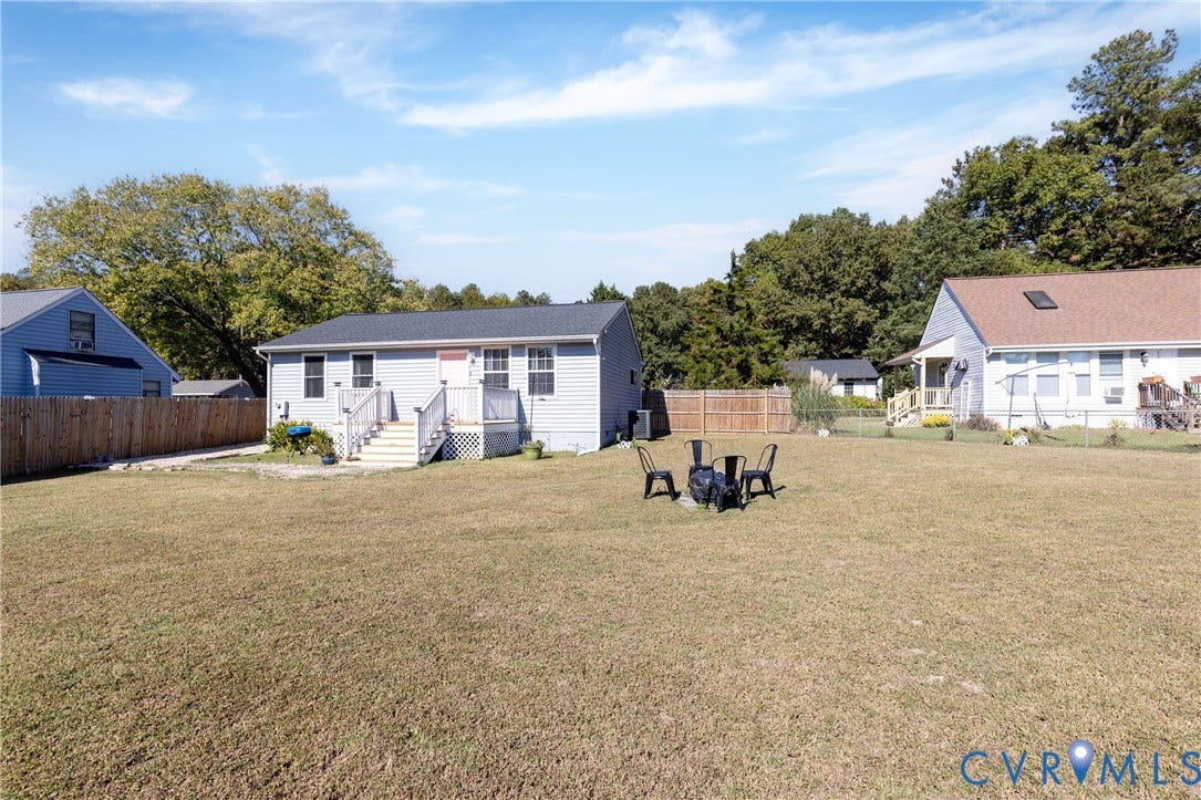 3705 Yard Arm Drive, Chesterfield, VA 23831 Expansive backyard featuring a large grass lawn, perimeter wood fencing, and an elevated rear deck with white railing