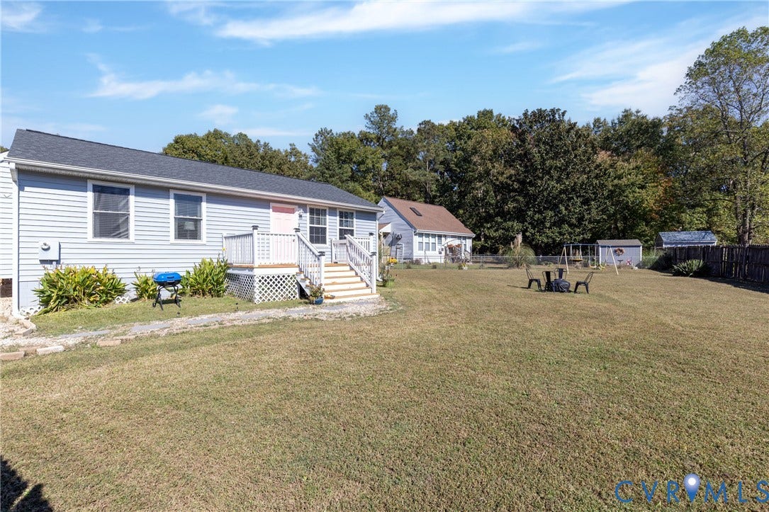 3705 Yard Arm Drive, Chesterfield, VA 23831 Large backyard featuring a grass lawn, privacy fencing, a storage shed, and a raised exterior deck with railing