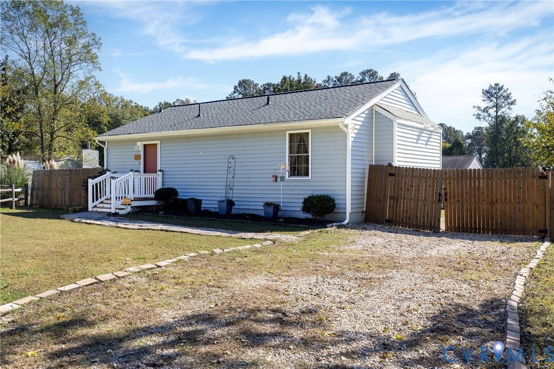 3705 Yard Arm Drive, Chesterfield, VA 23831 Light grey vinyl-sided exterior featuring an asphalt shingle roof, gravel driveway, wood-picket fencing, and a front entry porch with white railings