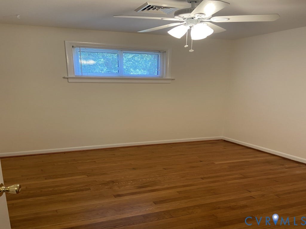 8358 Patrick Henry Boulevard, Mechanicsville, VA 23116 Room interior featuring wood-finish flooring, a ceiling fan with integrated light fixture, and a single-hung window with casing