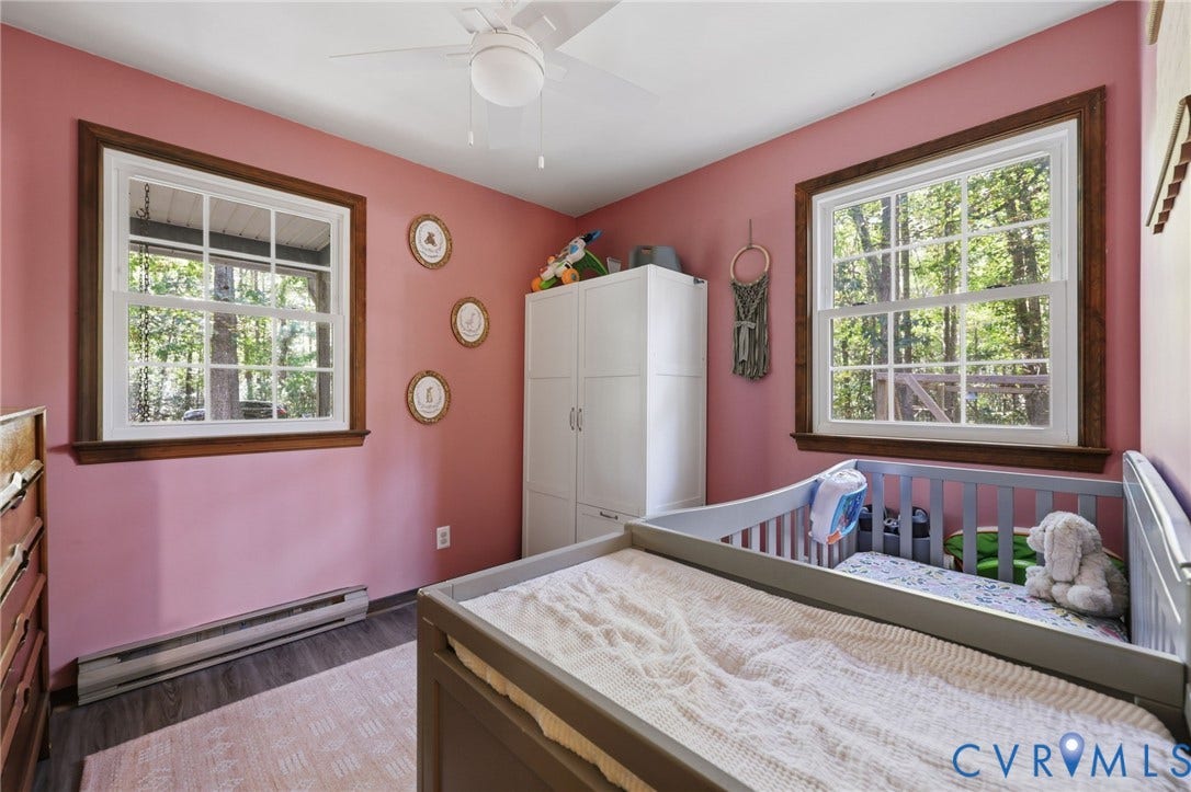 2764 Birdsong Lane, Powhatan, VA 23139 Bedroom #2 option downstairs featuring two windows with wood trim, wood-finish flooring, and a ceiling fan