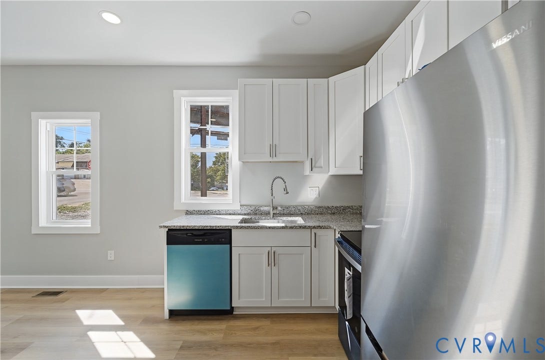 Kitchen featuring white cabinetry, stone-finish countertops, stainless steel appliances, and wood-finish flooring