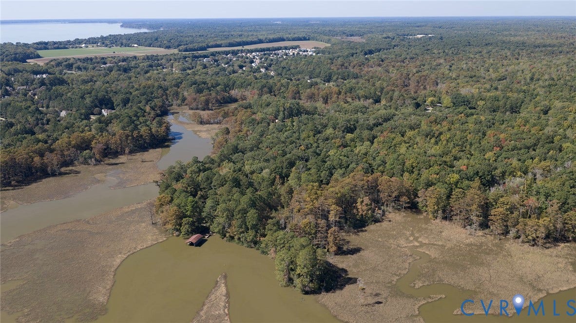 234 Sandy Bay Road, Williamsburg, VA 23185 Aerial expanse featuring tidal marshland, wooded acreage, and a private boat slip