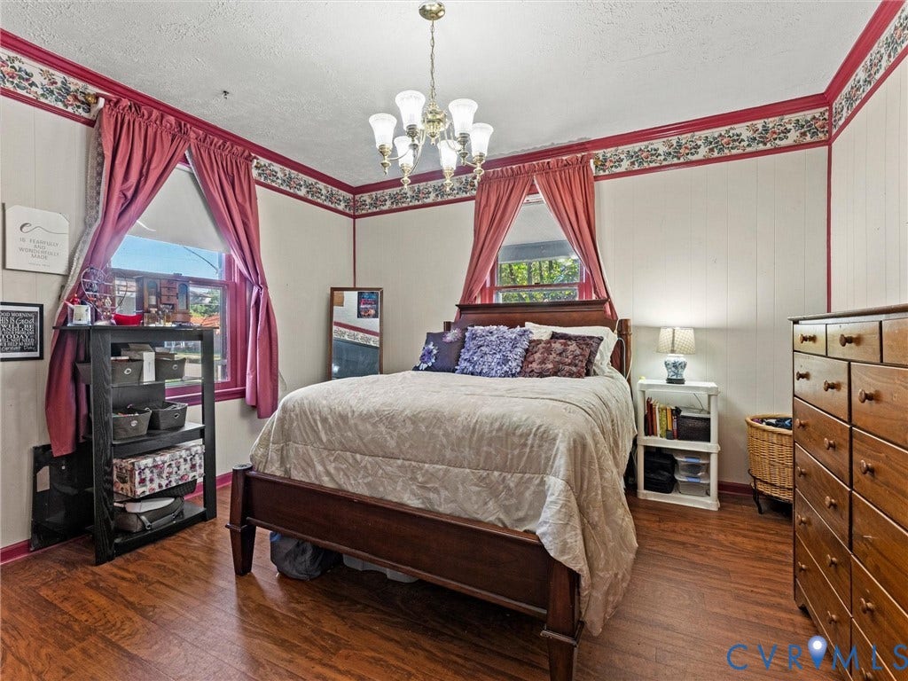 124 Suffolk Avenue, Chesterfield Highlands, Colonial Heights, VA 23834 Bedroom with wood-finish flooring, multi-light chandelier, and paneled walls with decorative border trim