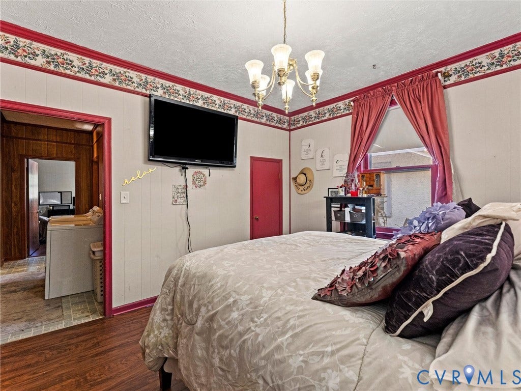 124 Suffolk Avenue, Chesterfield Highlands, Colonial Heights, VA 23834 Bedroom with wood-finish flooring, multi-arm chandelier, and floral wallpaper border