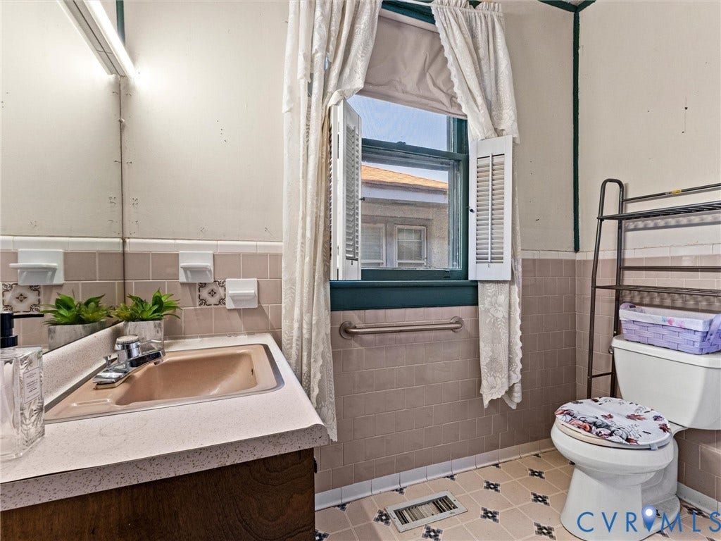 124 Suffolk Avenue, Chesterfield Highlands, Colonial Heights, VA 23834 Bathroom featuring a vanity with an integrated sink, wall-mounted horizontal grab bar, ceramic wall tile wainscoting, and patterned vinyl tile