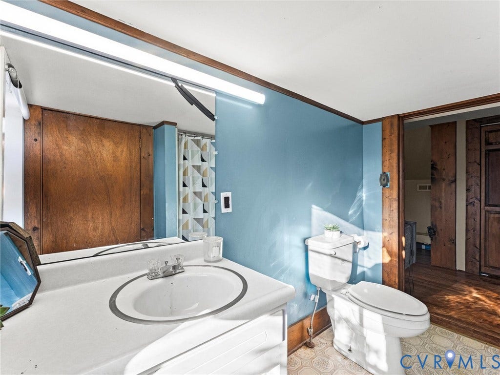 124 Suffolk Avenue, Chesterfield Highlands, Colonial Heights, VA 23834 Bathroom featuring a white vanity with an integrated oval basin, a full-width wall-mounted mirror, and patterned resilient flooring