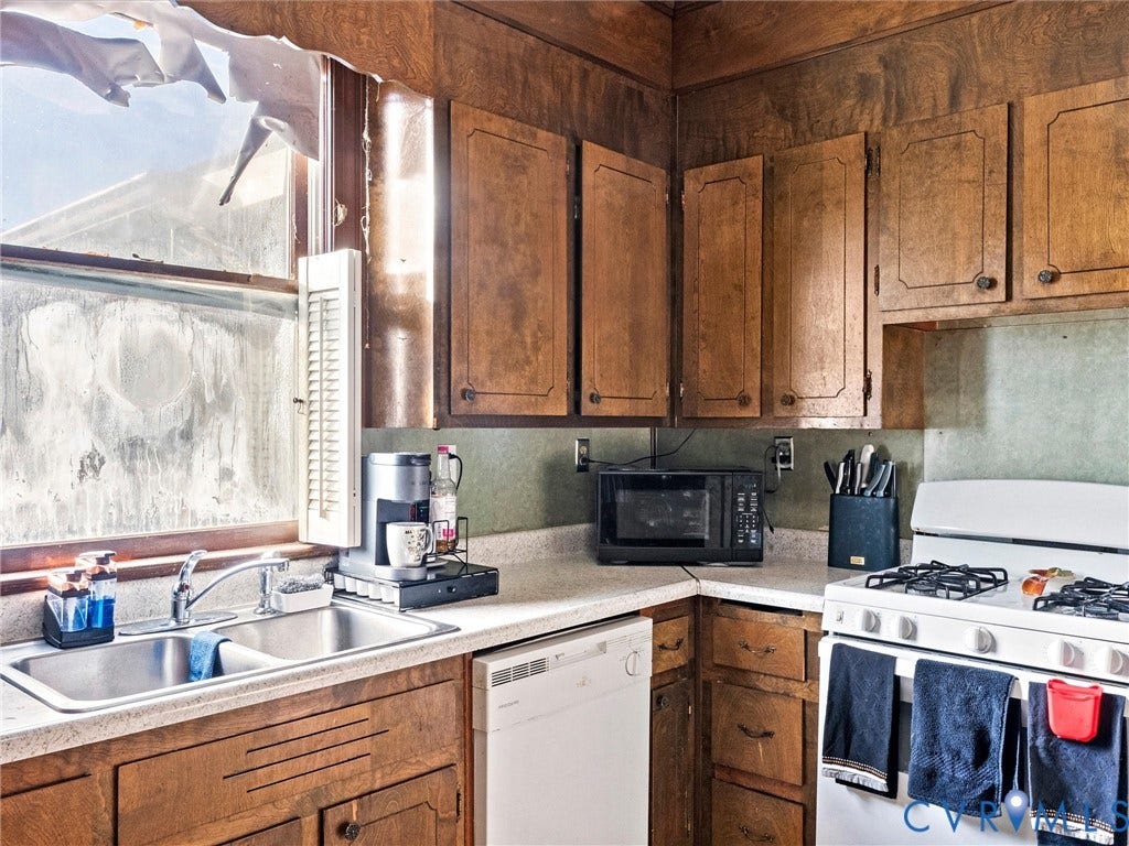 124 Suffolk Avenue, Chesterfield Highlands, Colonial Heights, VA 23834 Kitchen featuring wood cabinetry, double-basin stainless steel sink with high-arc faucet, and light-toned countertops