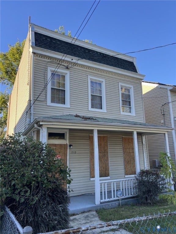 1512 N 23rd Street, Church Hill, Richmond, VA 23223 Two-story residence featuring light-colored siding, a front porch with a white railing, and a mansard-style roof