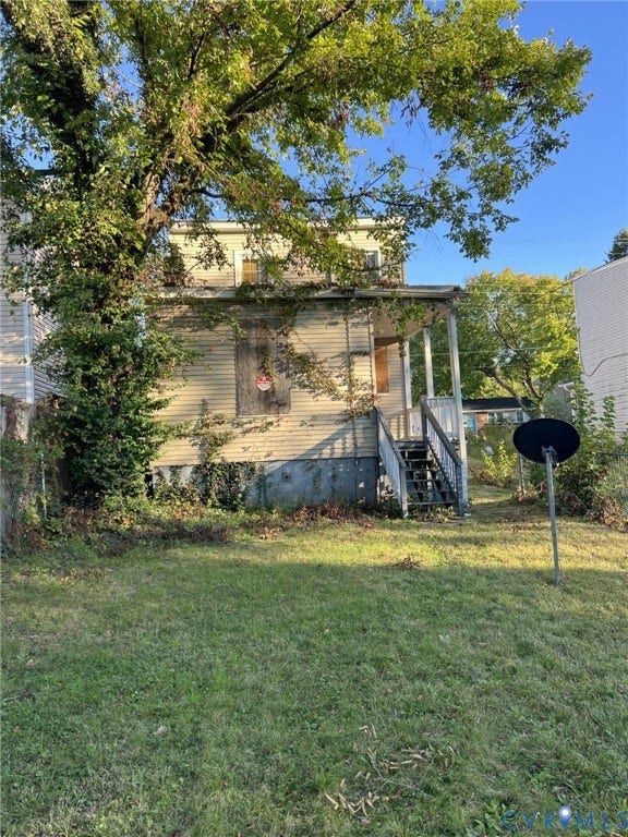 1512 N 23rd Street, Church Hill, Richmond, VA 23223 Exterior of a multi-story residence featuring horizontal siding, a covered porch with wooden stairs, and a level yard with mature trees