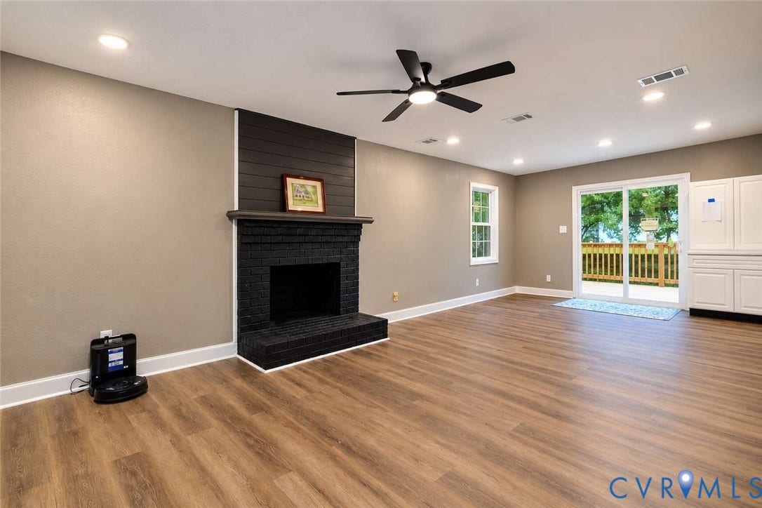 7300 Key Deer Court, Deer Run, Midlothian, VA 23112 Living area featuring wood-finish flooring, a floor-to-ceiling brick fireplace with wood-paneled accent detail, recessed lighting, ceiling fan, and sliding glass door with exterior deck access